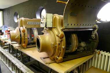 Two projectors lying on a bench, open for repairs